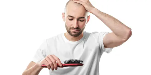 Bald man looking to a comb with worried face